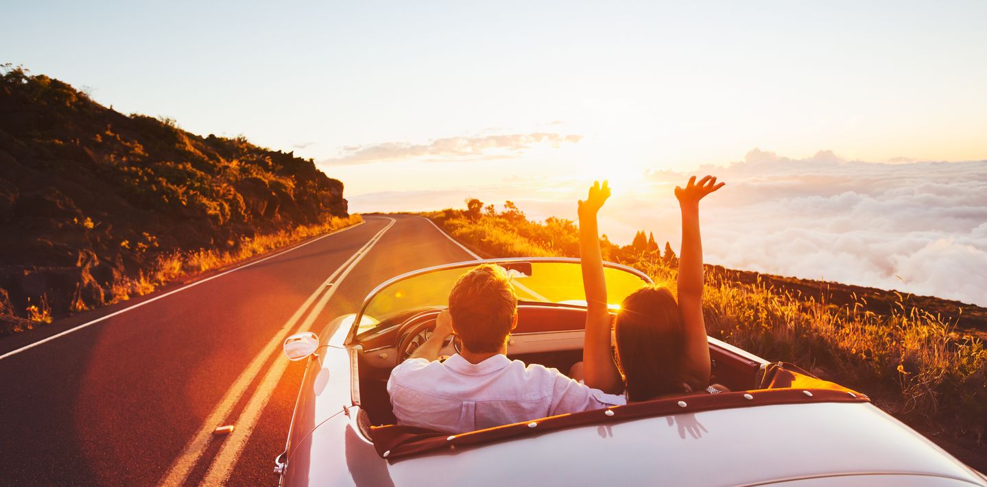 Couple driving off into the sun